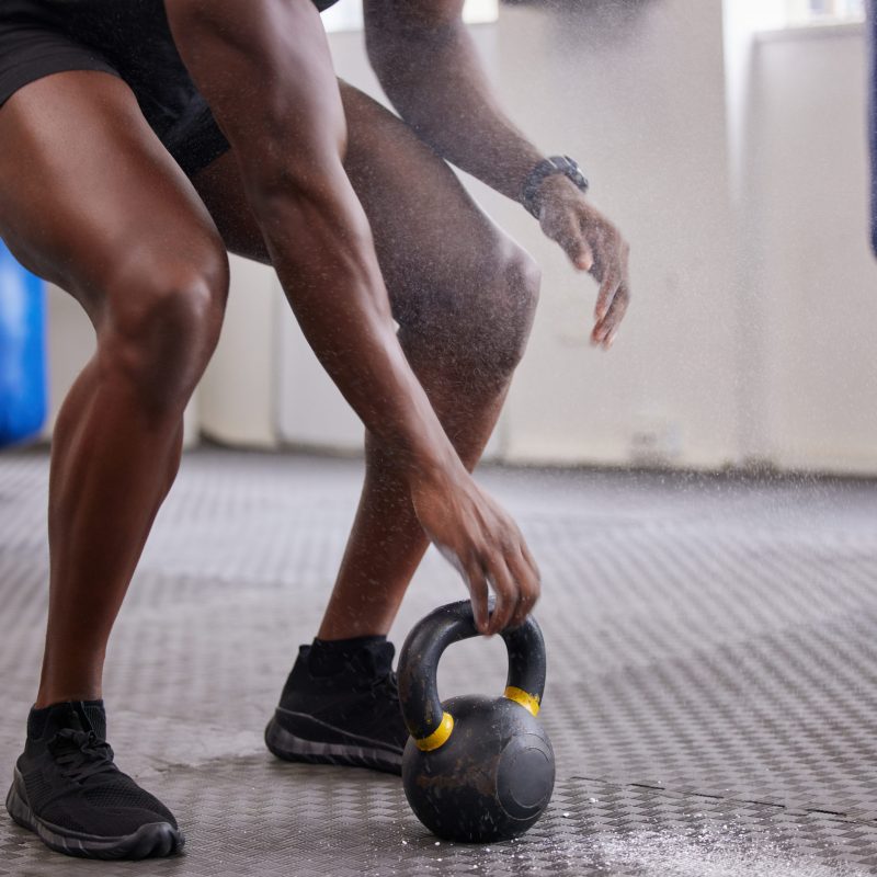 Kettlebell, hands and legs of man training for weightlifting, fitness workout and sports challenge .